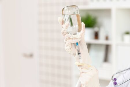The doctor prepares a dropper with a solution of medicine. Close up.の写真素材