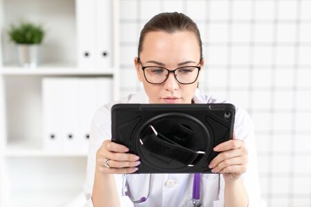 Veterinarian examines the results of tests on the tablet. Close up.の写真素材