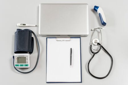 Top view table doctor work desk with laptop, Blood pressure, Stethoscope with clip board and pen.の写真素材