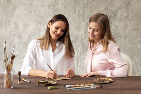 Learning calligraphy in art workshop. Teacher and students. Art school handwriting.の写真素材