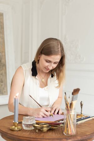The girl artist is inspired and paints a picture. Holds a brush. Soft focus. Interior artists workshop.の写真素材