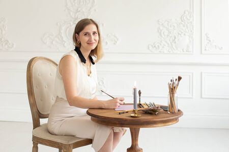 The girl artist is inspired and paints a picture. Holds a brush. Soft focus. Interior artists workshop.の写真素材
