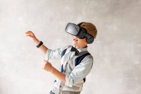 Little boy in VR glasses looks up and laughの写真素材