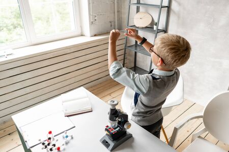 Young boy preparing samples for examination under microscopeの写真素材