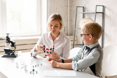 Young schoolboy attentively listen his tutors lesson of chemistryの写真素材