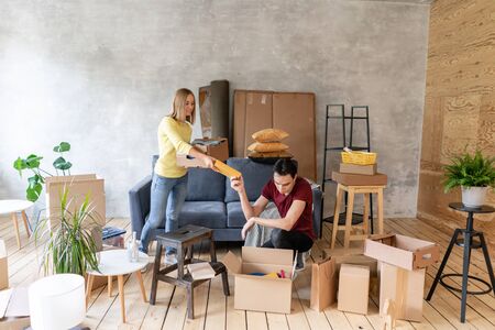 Happy smiling couple moving in a new house and unpacking cartons boxes, relocation and renovation conceptの写真素材