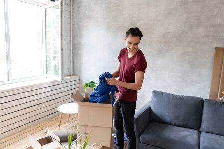 Happy people packing cardboard box, concept moving house. Young couple moving to a new apartment together. Relocation conceptの写真素材