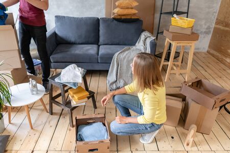 Happy people packing cardboard box, concept moving house. Young couple moving to a new apartment together. Relocation conceptの写真素材