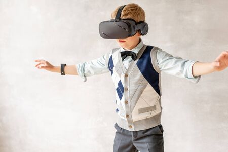 Young schoolboy in VR headset explore space around himの写真素材