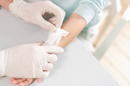 Sports injury. Doctor makes bandage on head patient, in the hospital.の写真素材