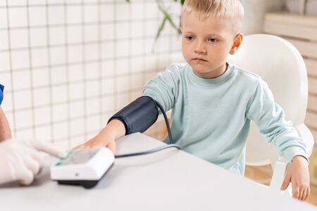 Doctor measuring blood pressure of a little boy. Diagnostic, healthcare, medical service. Doctor pediatrician conceptの写真素材