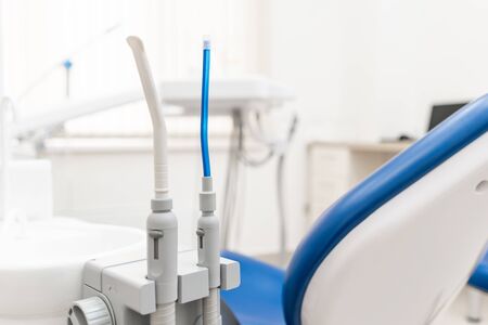 Close-up dentist saliva ejector. Dental work in clinic. Operation, tooth replacement. Medicine, health, stomatology concept. Office where dentist conducts inspection and concludes.の写真素材