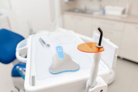 Dental polymerization lamp with UV light and laser. Stomatological instrument in the dentist clinic. Medicine, health, stomatology concept.の写真素材