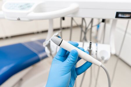 Close-up hand of dentist in the glove holds dental high speed turbine. Office where dentist conducts inspection and concludes.の写真素材