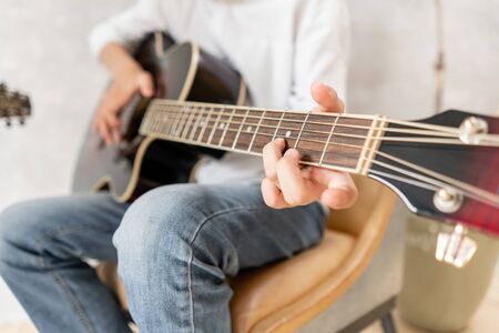 European male posing with acoustic guitar in his handsの写真素材
