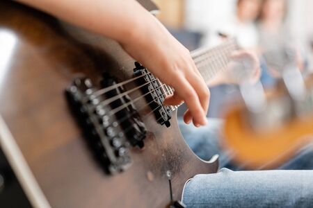 Young male hands playing electric guitar. Concept of learning to play a musical instrumentの写真素材