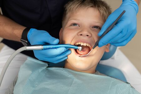 Closeup of young boys teeth being drilled by dentistの写真素材