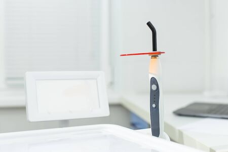 Dental polymerization lamp with UV light and laser. Stomatological instrument in the dentist clinic. Medicine, health, stomatology concept.の写真素材