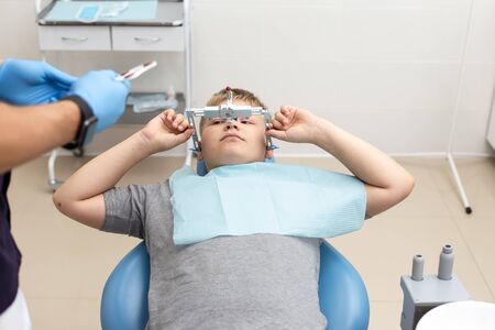 Doctor preparing his patient for fixing up orthodontic archの写真素材