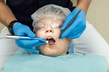 Little boy lays under anesthesia on dentist coachの写真素材