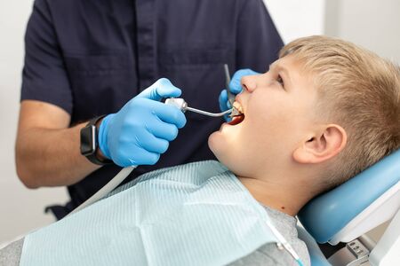 Dentist prepares for future operation and mouthwashing his patientの写真素材