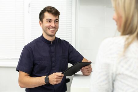 Charming doctor talks with blond woman at hospital. Selective focusの写真素材
