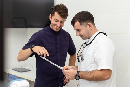 Two stomatologiests talking about results of x-ray of their patients jawの写真素材