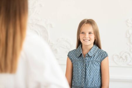 Cute young girl smile in anticipation of gift from her mother. Soft focus
