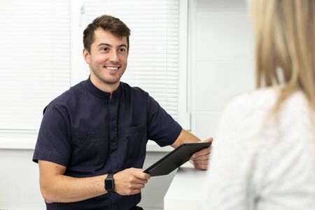 Smiling dentist discuss terms of future work with client. Selective focusの写真素材