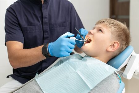 Calm dentist use mouthwash on his patients teethの写真素材