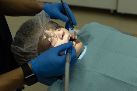 Closeup of dentist operation over young boys teethの写真素材