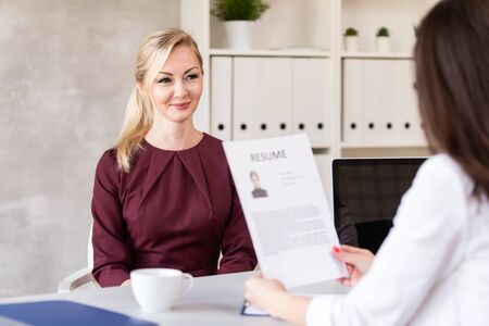 Employer examine resume and talks with candidate for job in her companyの写真素材