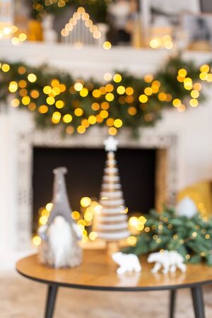 Journal table standing in front of Xmas-style decorated fireplace with toys plased on it. Selective focusの写真素材
