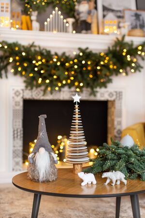 Journal table standing in front of Xmas-style decorated fireplace with toys plased on it. Selective focusの写真素材