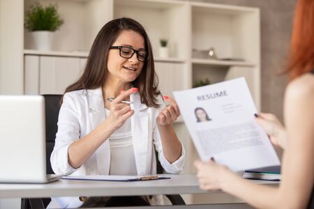 Charming HR manager in friendly manner leads a job interview with one of the candidates on post. Selective focusの写真素材