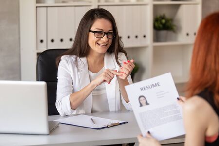 Charming HR manager in friendly manner leads a job interview with one of the candidates on post. Selective focusの写真素材