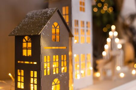 Closeup of paper houses with lights inside standing on background of other decorations. Selective focusの写真素材