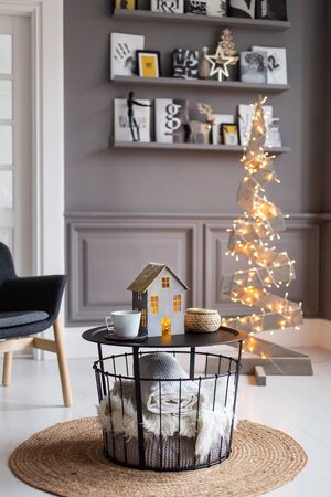 Nizhniy Novgorod, Russia - November 11, 2019: Photo studio 2.8. Journal table with paper home and cups on it and white blanket under it stands in middle of cozy living room. Selective focusのeditorial素材