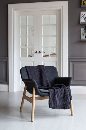 Nizhniy Novgorod, Russia - November 11, 2019: Photo studio 2.8. Armchair with black plaid laying on it stands in living roomのeditorial素材
