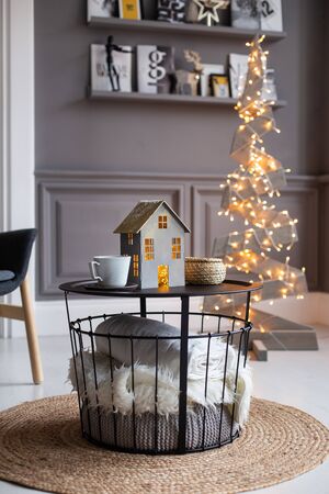 Nizhniy Novgorod, Russia - November 11, 2019: Photo studio 2.8. Journal table with paper home and cups on it and white blanket under it stands in middle of cozy living room. Selective focusのeditorial素材