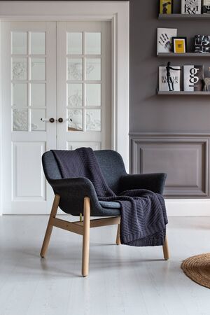 Nizhniy Novgorod, Russia - November 11, 2019: Photo studio 2.8. Armchair with black plaid laying on it stands in living roomのeditorial素材