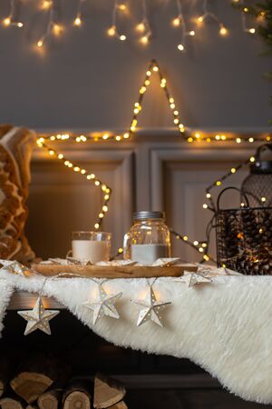 Composition of star made of garland, tray with food and christmas tree placed on bench. Holiday atmosphereの写真素材