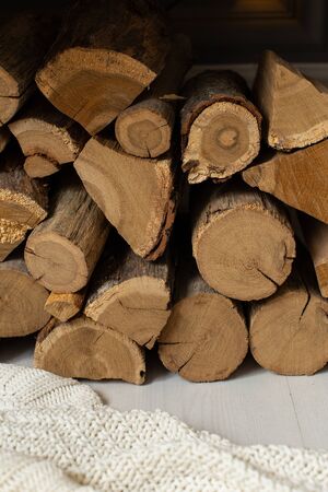 Closeup of firewood pile laying on white blanket under wooden benchの写真素材