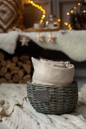 Nizhniy Novgorod, Russia - November 11, 2019: Photo studio 2.8. Basket with gray blanket inside stay on floor in front of decorated rustic bench. Selective focusのeditorial素材
