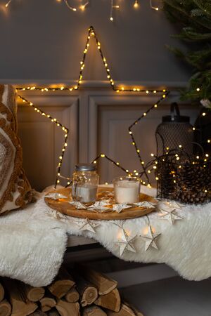 Composition of star made of garland, tray with food and christmas tree placed on bench. Holiday atmosphereの写真素材