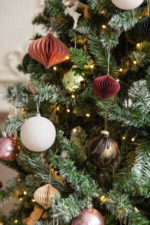Closeup of garland, balls and tiny toys hanging on Christmass treeの写真素材