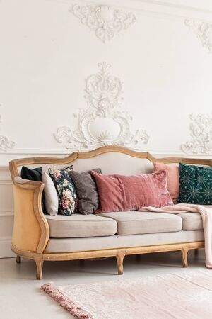 Sofa with lots of pillows stands in white appartment roomの写真素材