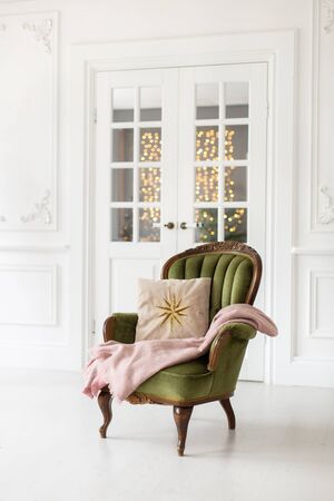 Soft pillow with star symbol and pink plaid lay on green armchair.の写真素材