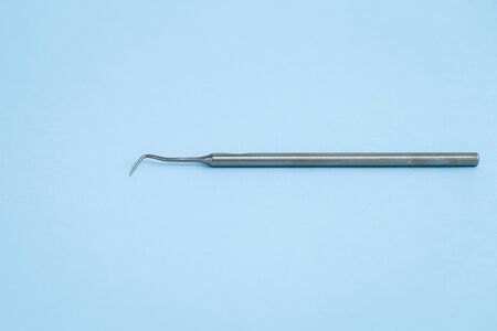 Stainless dental probe laying on light blue backgroundの写真素材