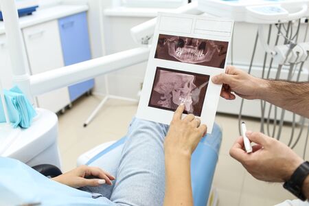 Dentist explains results of x-ray to his patient. Selective focusの写真素材